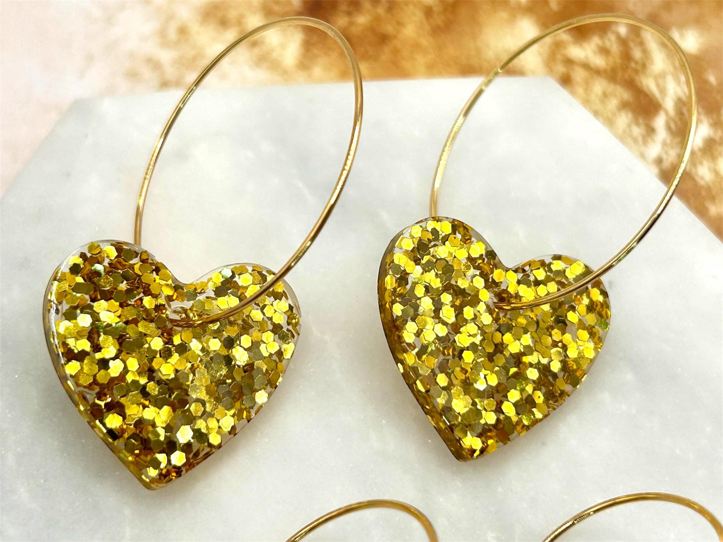 Handmade Heart Resin Charm Earrings with Gold Glitter on Gold Plated Hoops. Choice of size: large or small. Perfect gift or treat yourself!